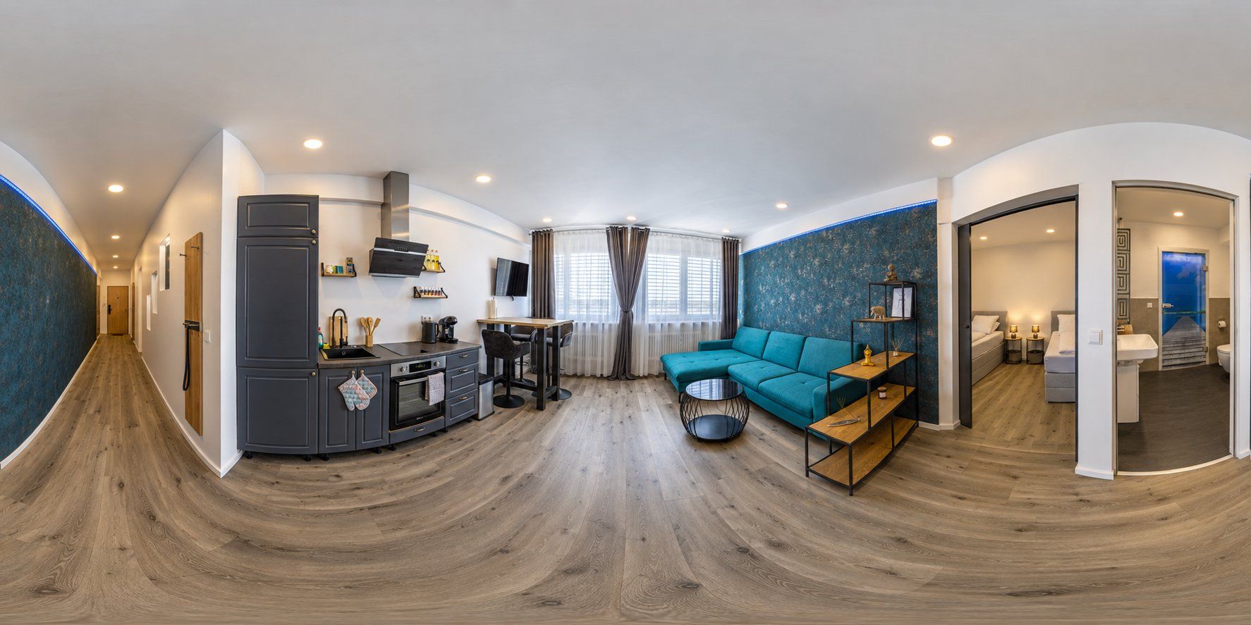 Panoramablick durch ein M4 Apartment: Küche, Essbereich, Wohnlandschaft und offenes Schlafzimmer